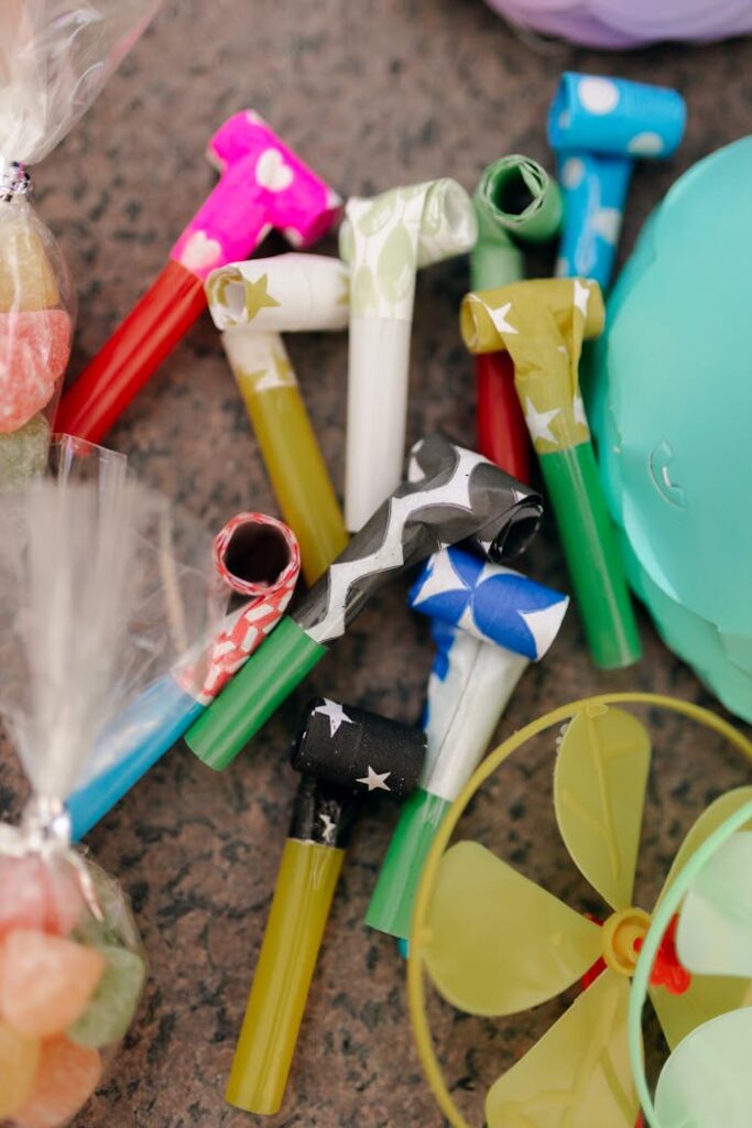 Vibrant party blowers and accessories for celebrations on a textured surface.